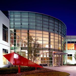Industrial and Technology cover image for epperson company's projects page showing a beautiful design artchitectural building at night with red art piece accent by the entrance night sky